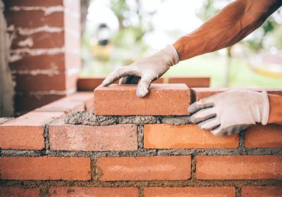 professional-construction-worker-laying-bricks-and-building-barbecue-in-industrial-site.jpg